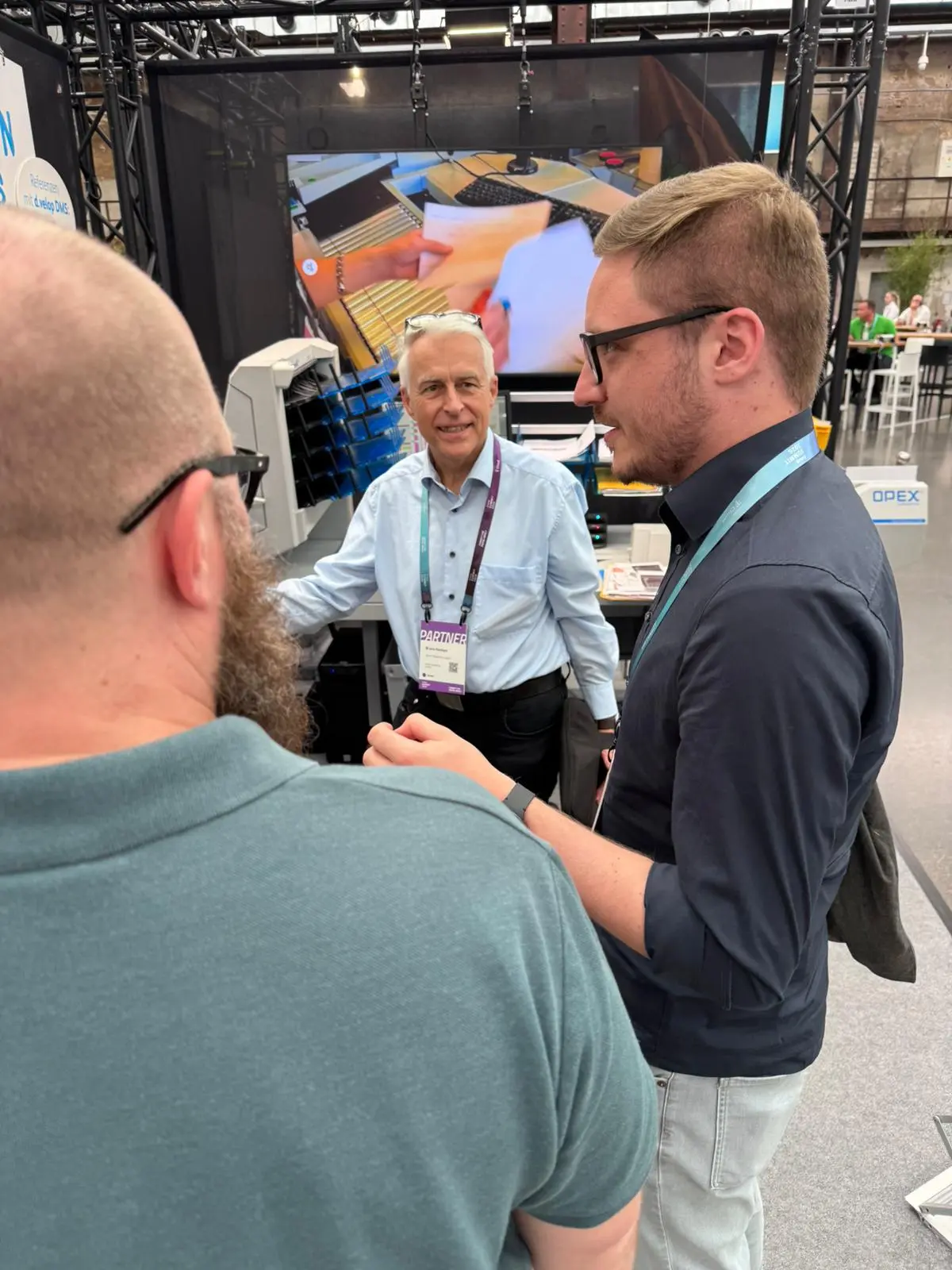 Fachgespräch am Stand vor dem laufenden OPEX-System