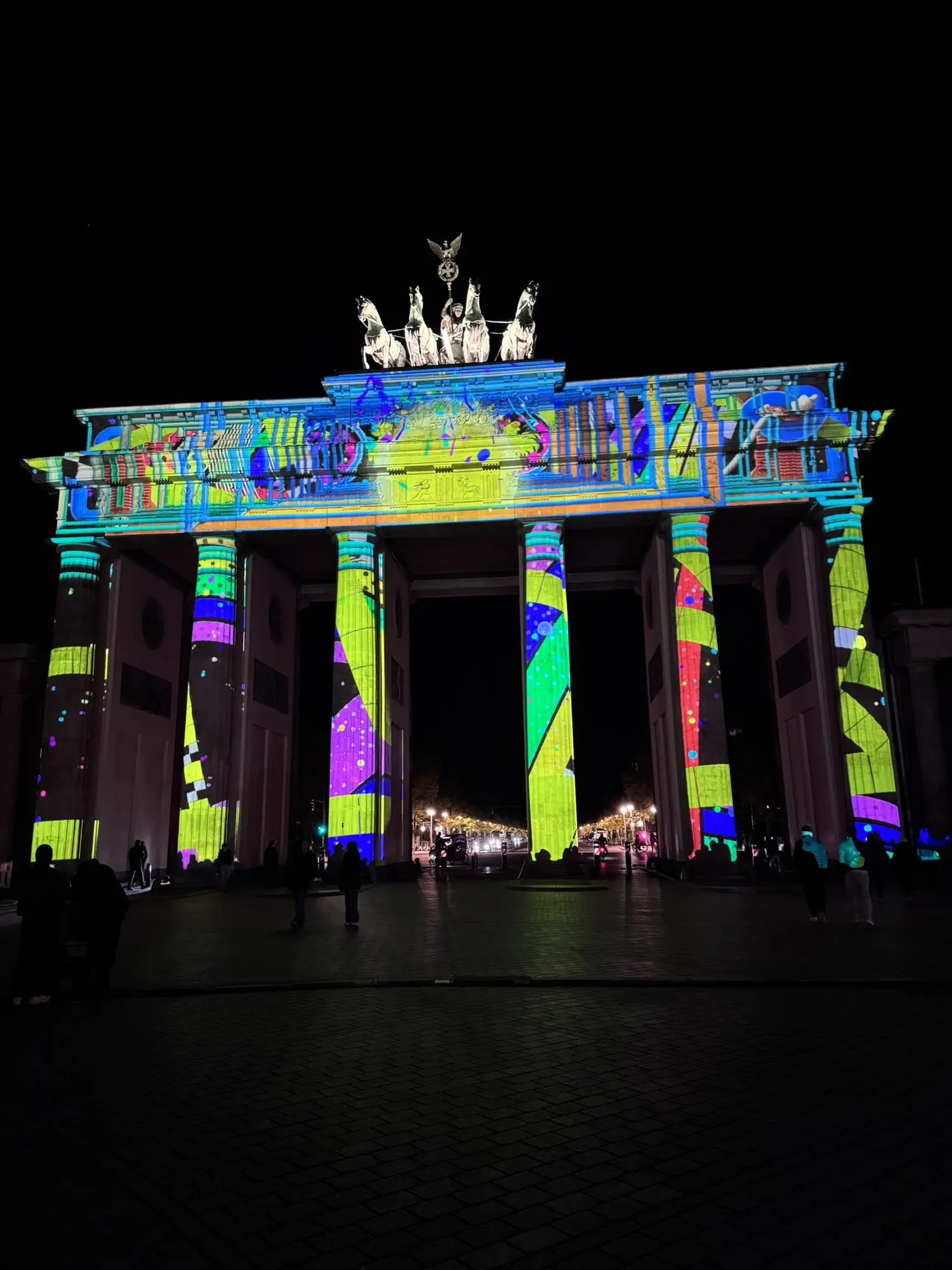 Das Brandenburger Tor bei Nacht mit farbenfroher Lichtprojektion